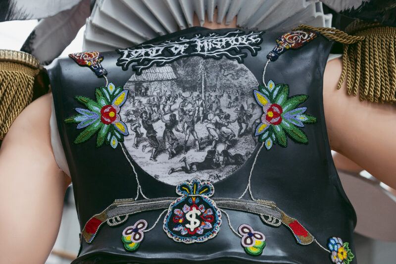 Close-up of a vest featuring colorful beadwork, a black-and-white historical battle scene, and stylized text reading "LORD OF THE THIEVES" at the top.