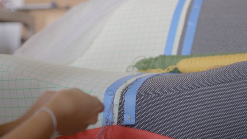 Hands holding a needle and thread.