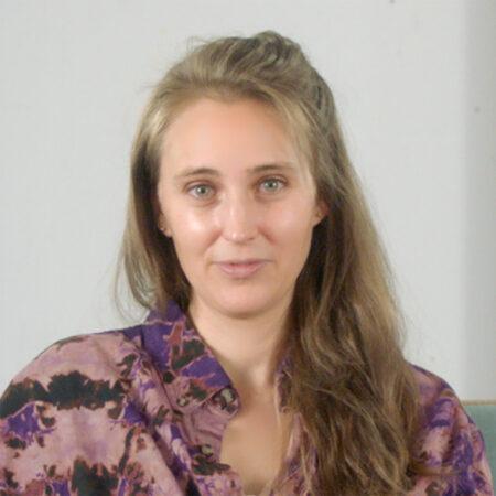 Loie Hollowell with long hair wearing a purple patterned shirt.